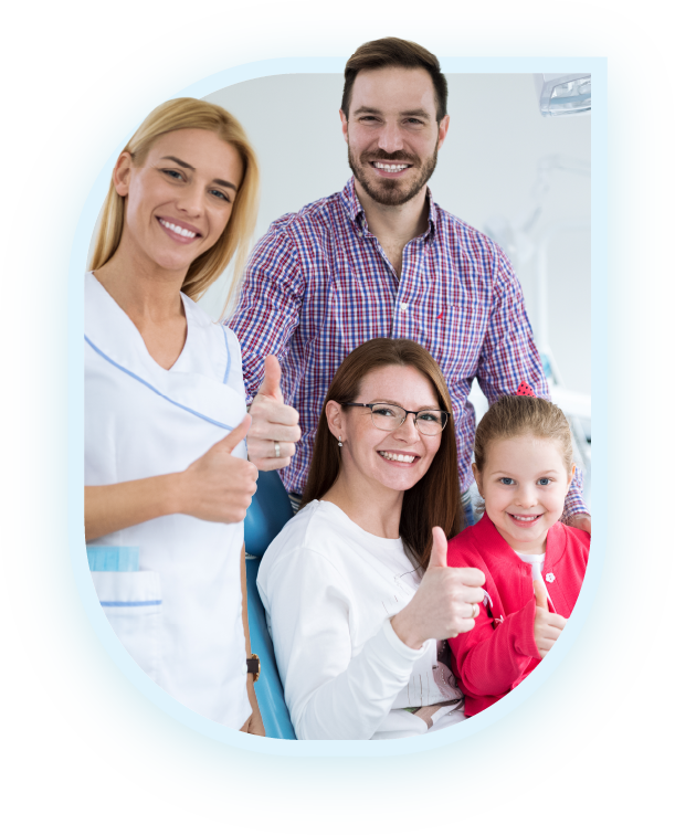 A dentist and her assistant standing with a family of three, all smiling and giving thumbs up in a dental office | Pleasant Dental